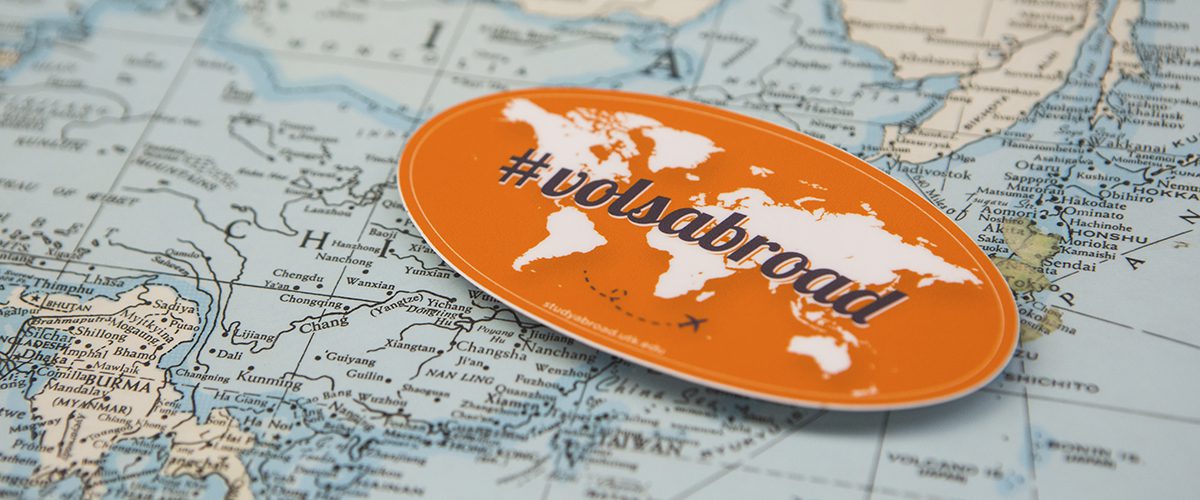 A sticker that says #volsabroad sits on a map.