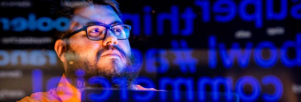 A man's face with digital words reflected over it