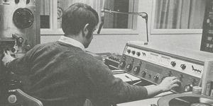 A black and white photo of someone in an old radio station