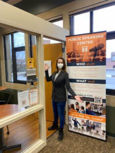 A masked Megan Fields welcomes people to the Public Speaking Center in Hodges Library.