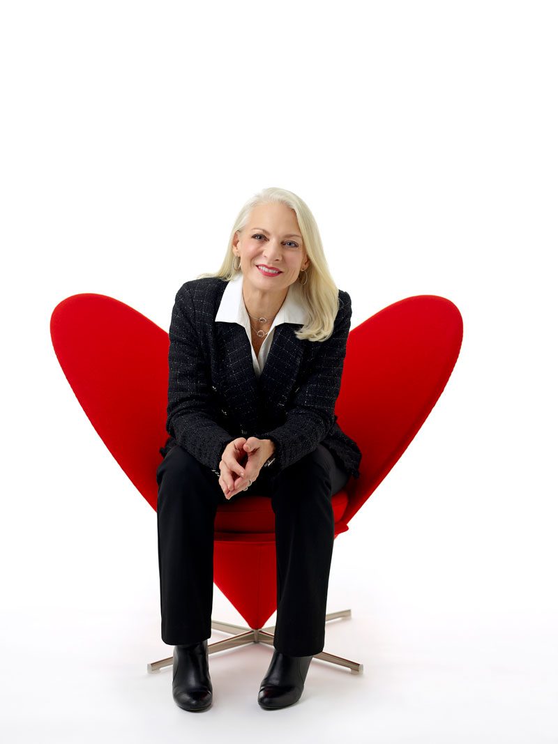 Alumna Sharon Price John in a red heart chair