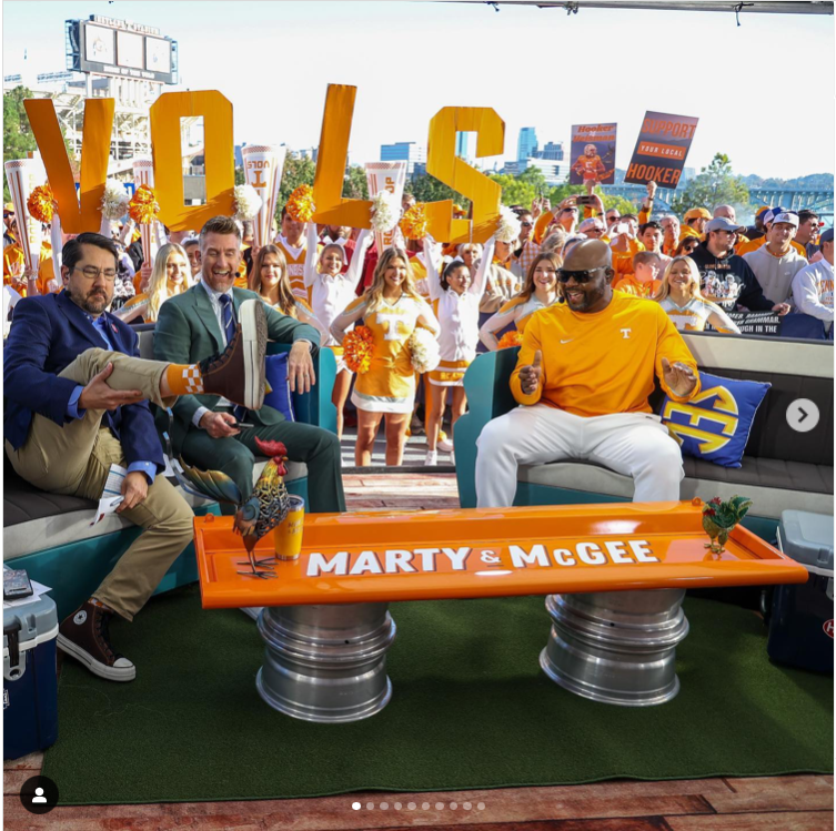 Alum Ryan McGee, co-host of the Marty and McGee show, surrounded by Vols fans holding up the letters to spell VOLS.