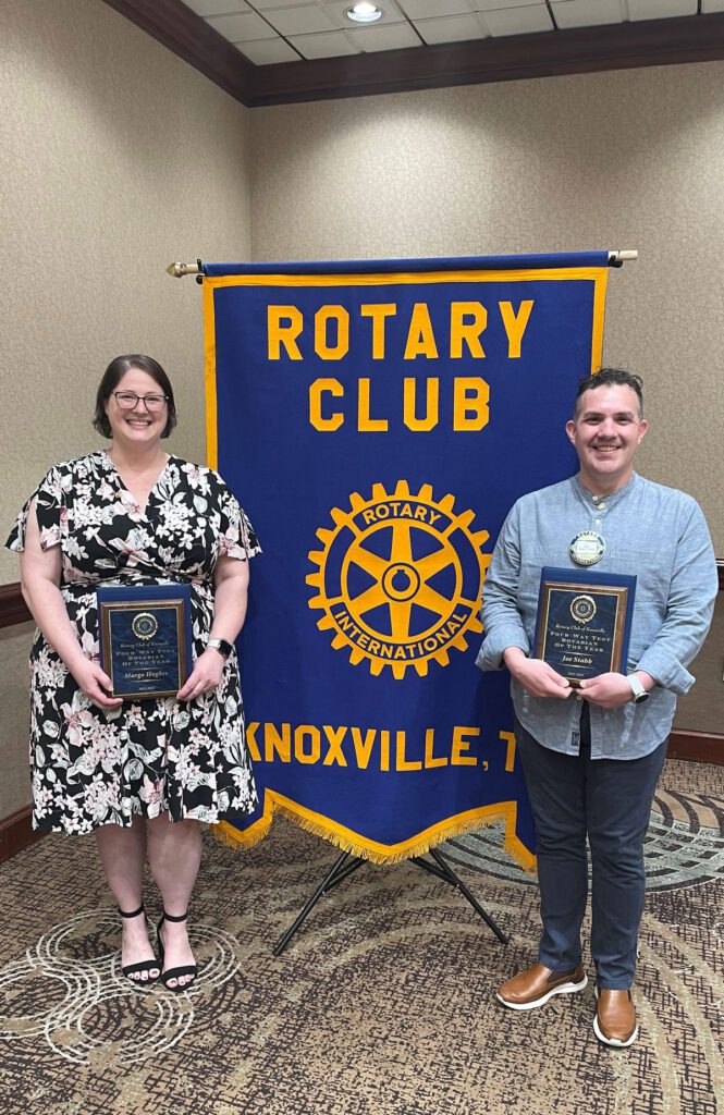 Margo Hughes, left, and Assistant Professor of Practice Joe Stabb, stand by a Rotary Club Knoxville flag with the Rotarian of the Year awards they were given. 