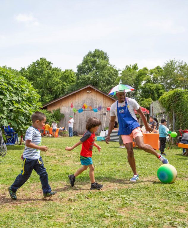 Alumnus Tyrone Beach plays soccer with children.
