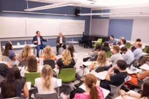 Students listen as Peyton Manning joins Associate Professor John Haas in the Communication Studies capstone course class.