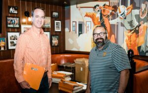 CCI alumni Peyton Manning and Barry Rice stand together in an office
