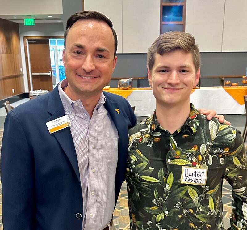 CCI Dean Joe Mazer wears a blazer and collared shirt while posing with student Hunter Sexton, who is wearing a button-up collared shirt with a leaf graphic.