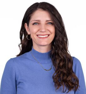 A headshot of Communication Studies Assistant Professor Jessica Frampton wearing a periwinkle shirt.