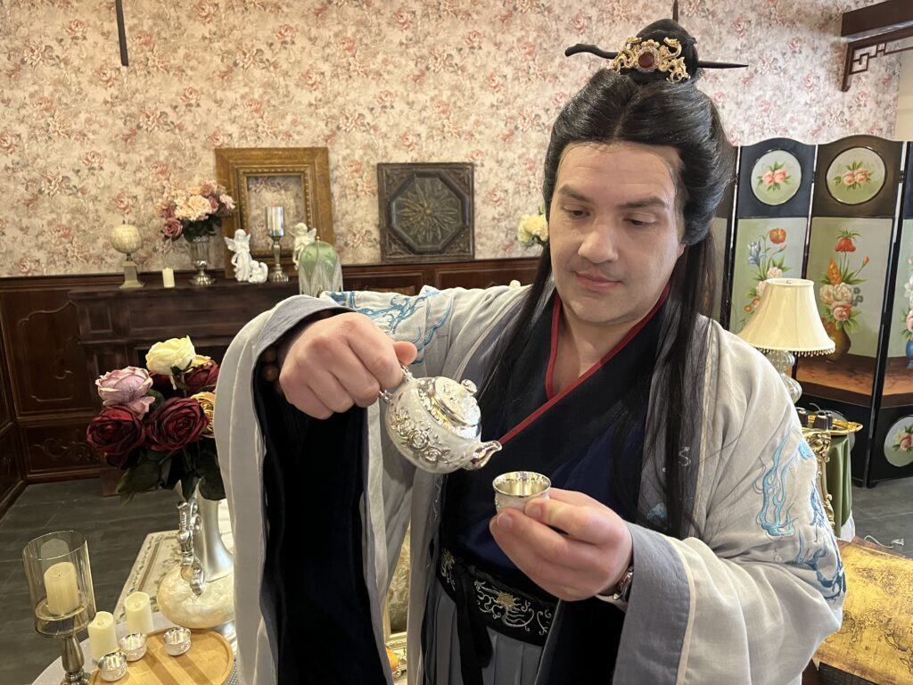 Joseph Stabb dressed in Hanfu, or Traditional Chinese clothing, in Shenyang, pouring tea. 