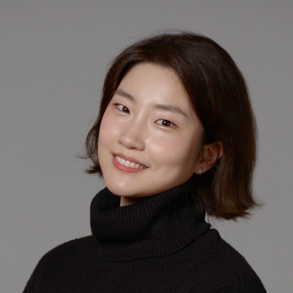 A headshot of Minjeong Kim wearing a black turtleneck sweather with a gray background behind her.