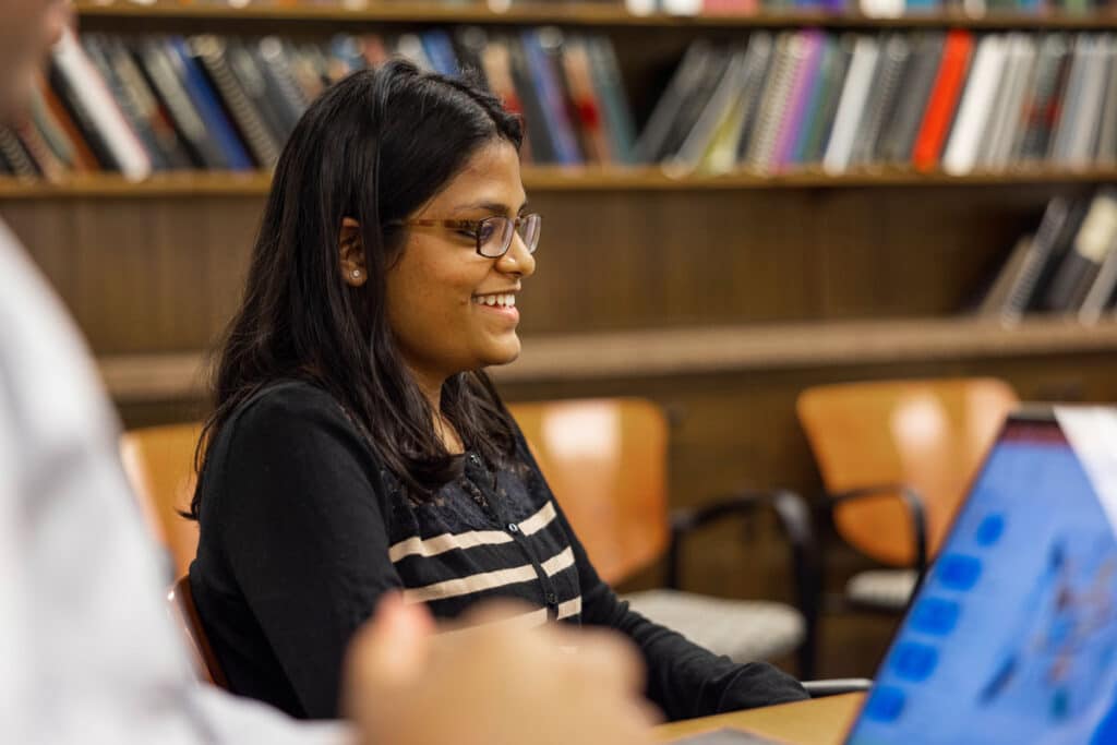 A doctoral student smiles during a class.