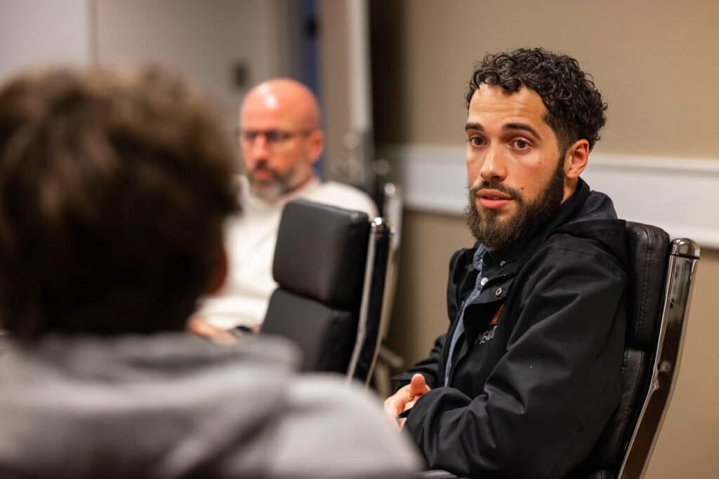 A doctoral student sits in a conference room for a communication studies course.