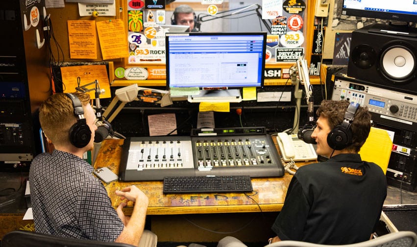 Two students sit in the WUTK studio and do a radio show.