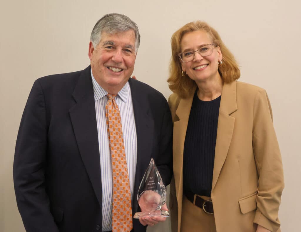 A photo of former Voice of the Vols and alumnus Bob Kesling and School of Journalism and Media director Amy Jo Coffey as they celebrate him winning the 2024 J&M Alumni of the Year Award.