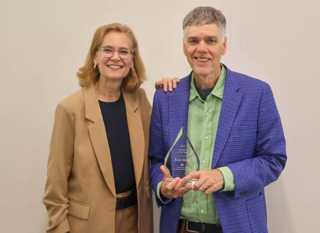 WUOT Program Director and Host of Studio 865/Flipside and Improvisations Todd Steed posing with his Alumni of the Year Award with School of Journalism and Media director Amy Jo Coffey.