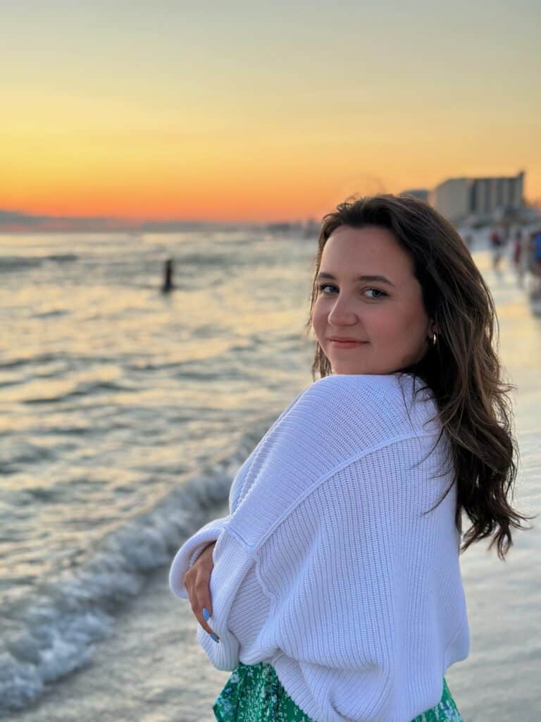 Caden Dyer stands on the beach at sunset