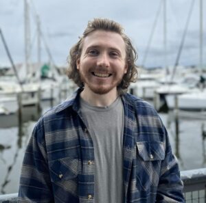 Joseph Edgerton by the water with boats around him