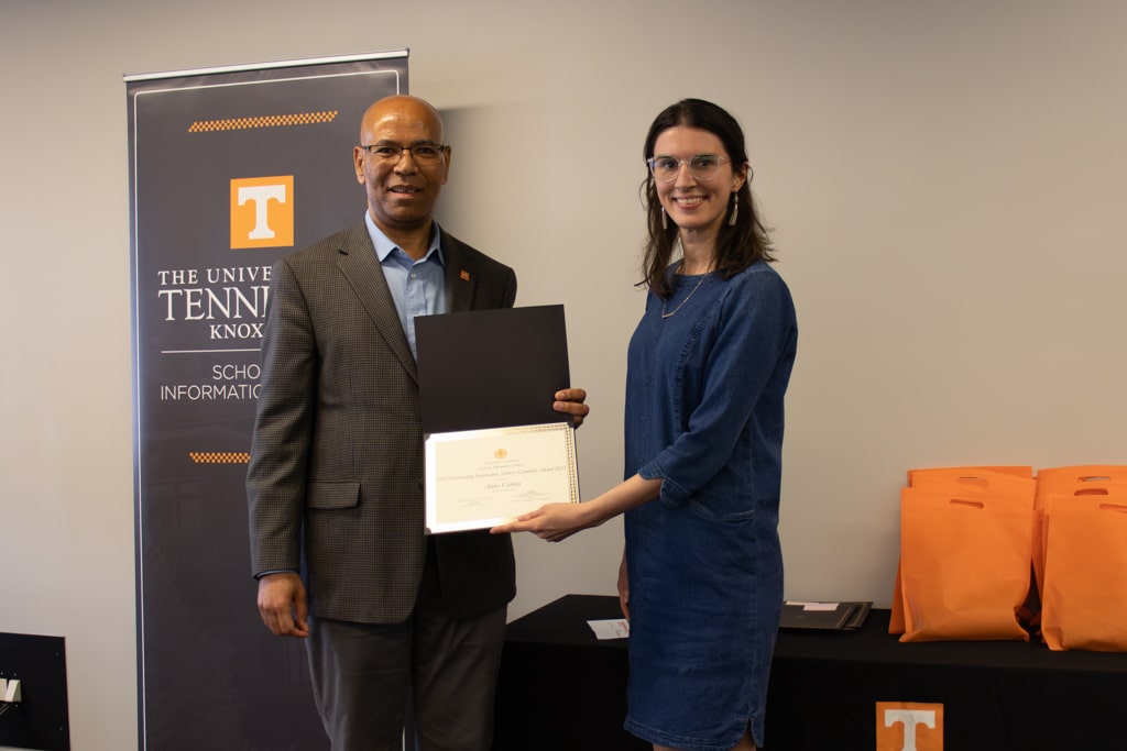 Anna Currey, right, accepts the CCI Outstanding Information Sciences Graduate Award from SIS Director Abebe Rorissa.