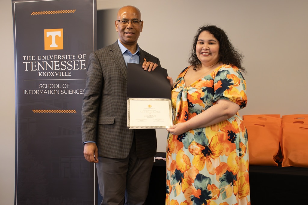 Nina Richard, right, accepts the Academic Achievement Award (On-Campus) from SIS Director Abebe Rorissa.