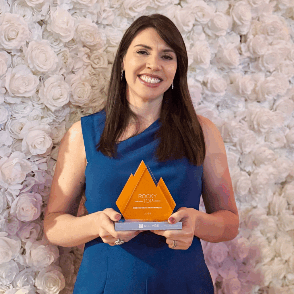College of Communication and Information alumna Julia Bonner and co-founder of Pierce Public Relations in a blue dress posing with her 2025 Rocky Top Buisness Award.