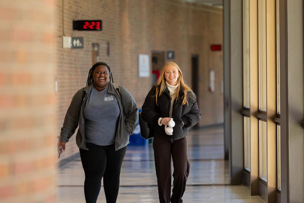 Two students from the inaugural cohort of the Alan and Wendy Wilson Communication and Leadership Academy walk down the hall of the third floor of C-C-I on the first day of spring classes in 2026.
