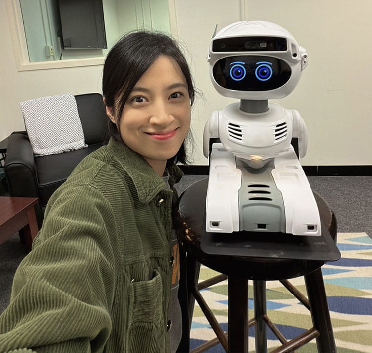 SIS master’s student Wanqi Zhang with one of the robots